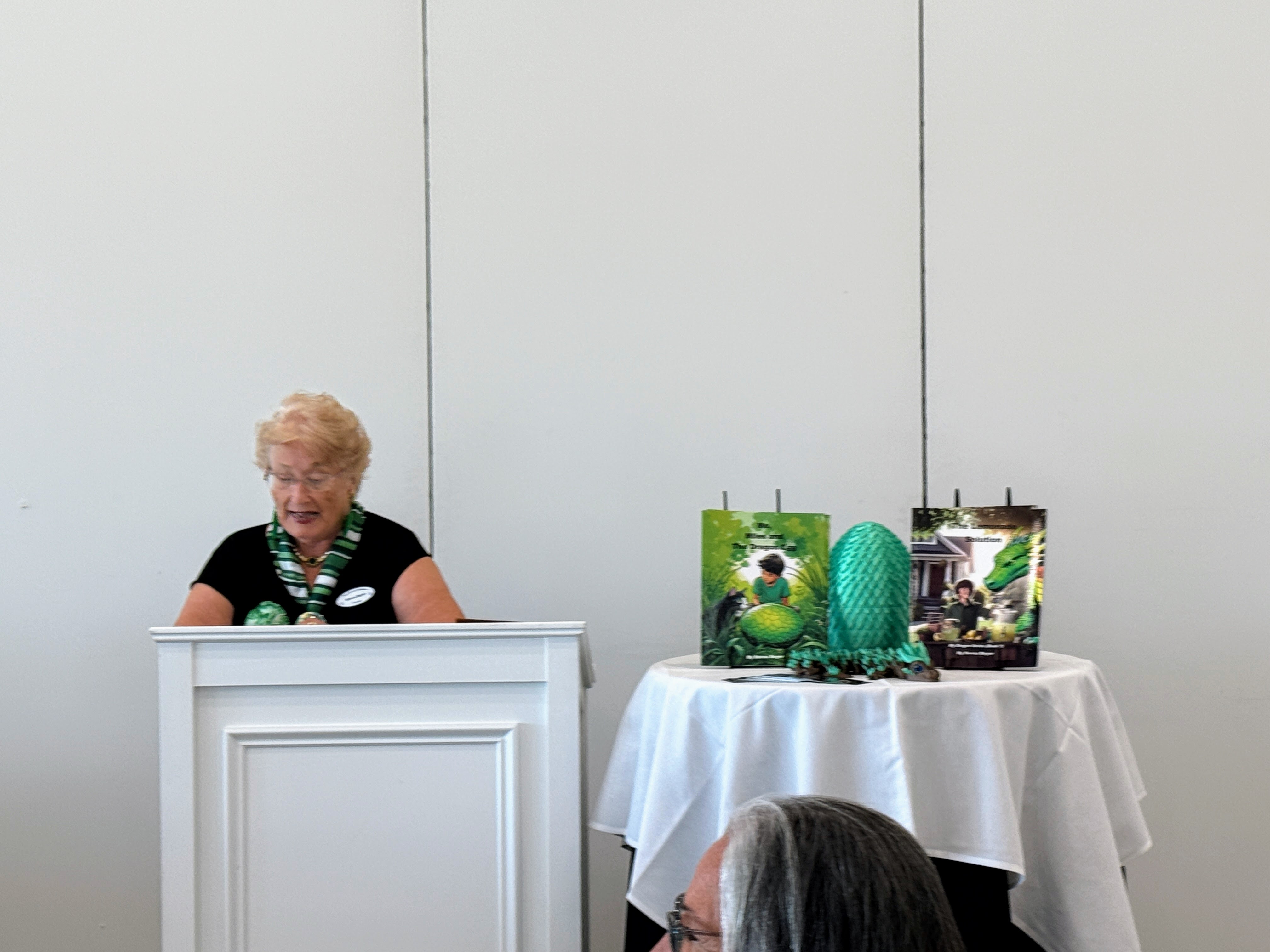 Donna reading at an event with her books on display